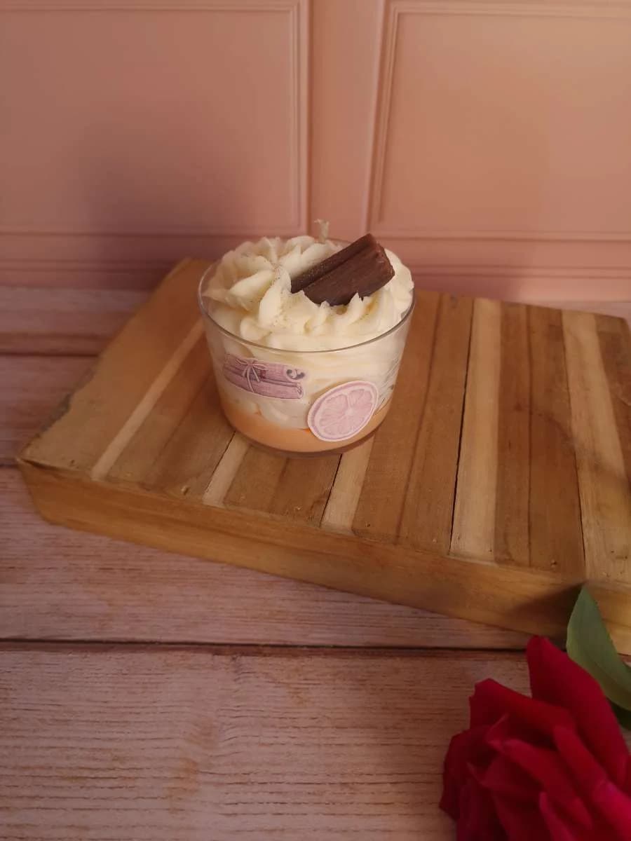 Bougie en verre avec cire pochée style chantilly et décor cannelle sur planche en bois